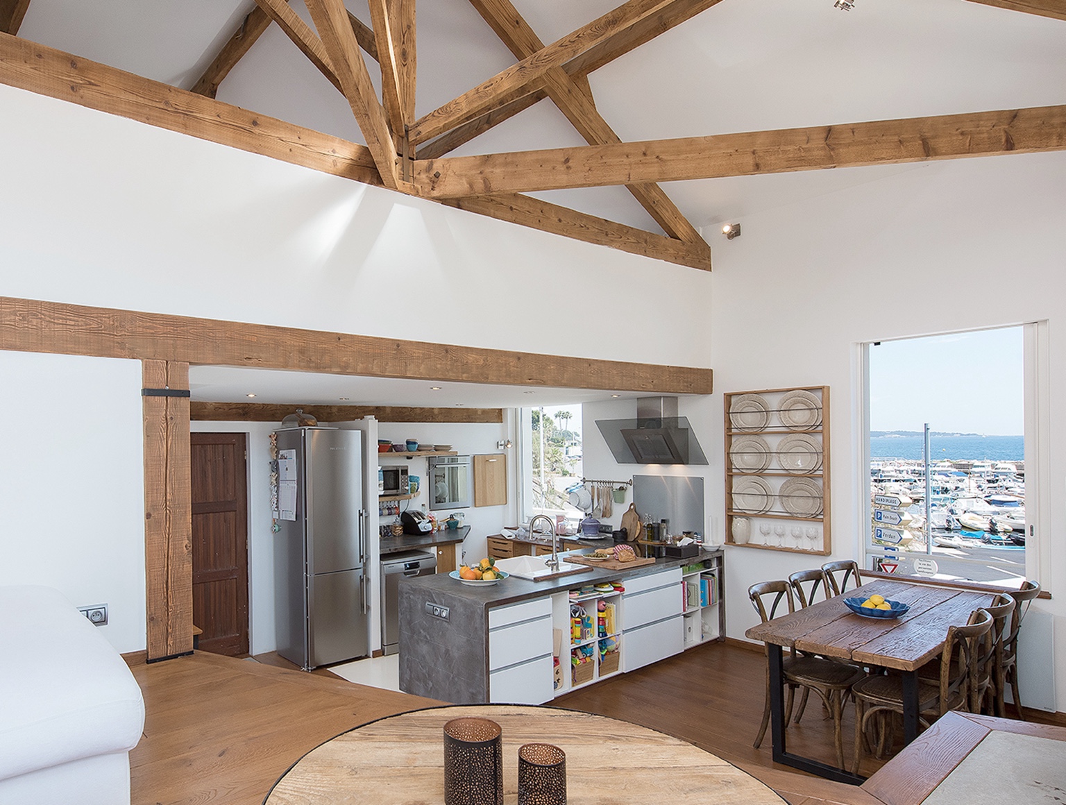 Open-plan living area with exposed beams and port view
